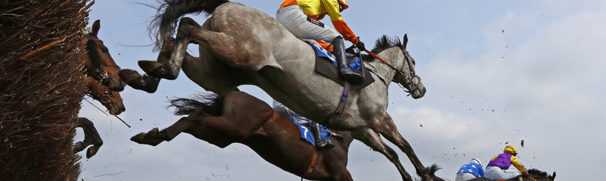 Two people on horses racing on the track at Exeter Racecourse