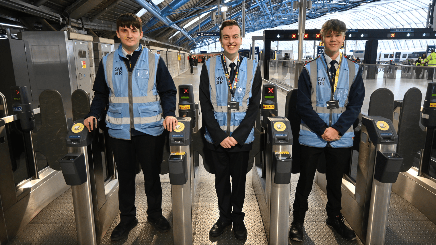 3 guys stand in front of train gate