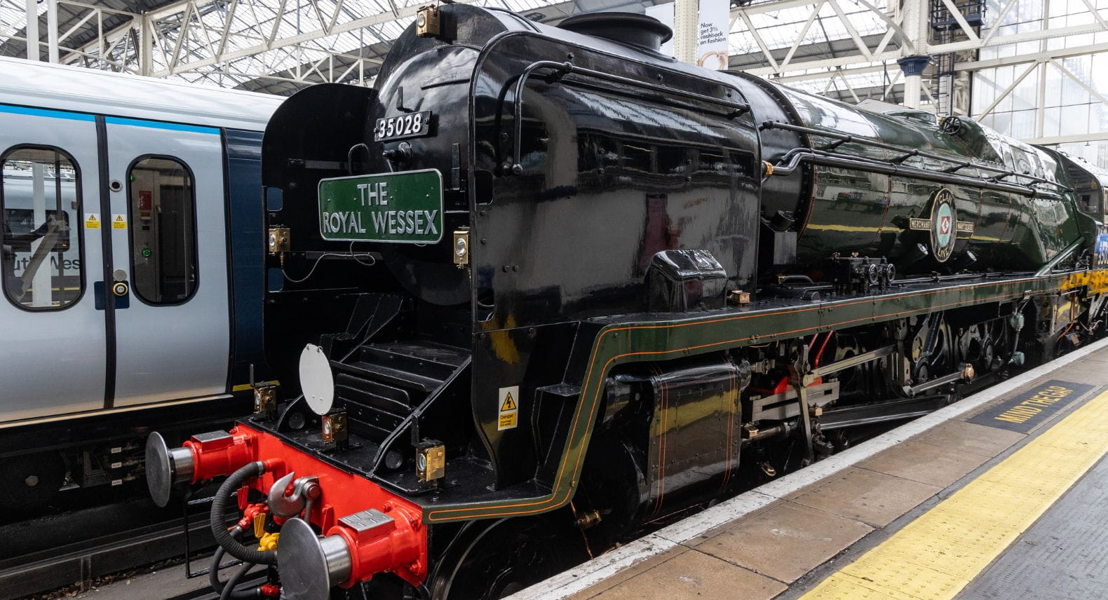 Dark green steam locomotive with a plate saying The Royal Wessex on the front