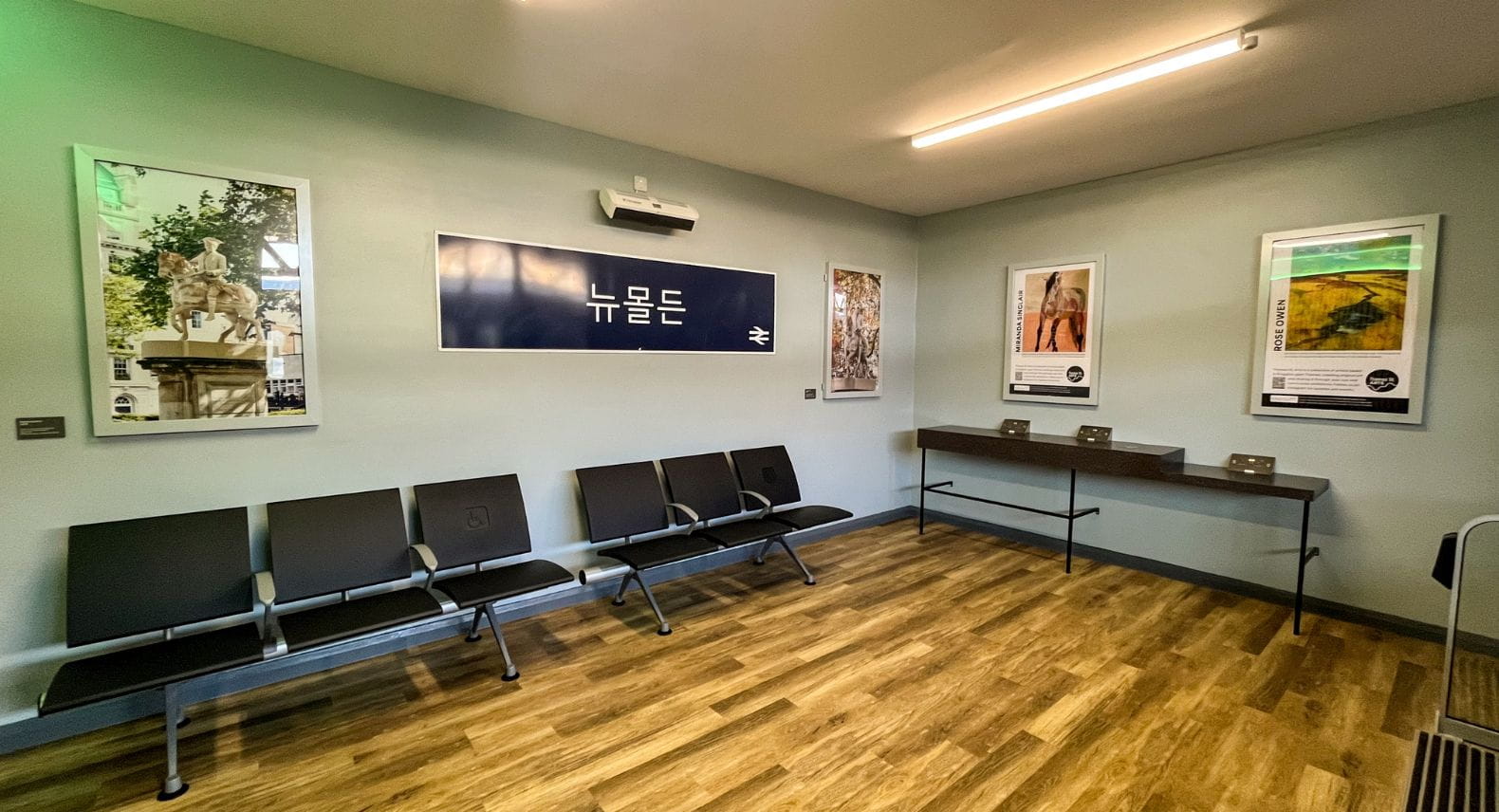 Internal view of new waiting room, showing accessible workspace, station sign in Korean and artworks