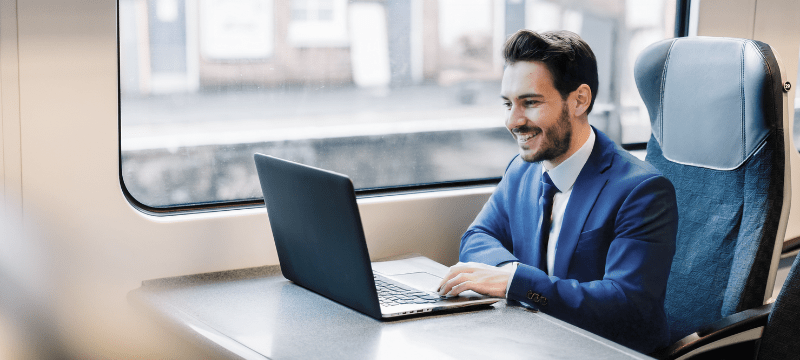 man sit in the train with a laptop
