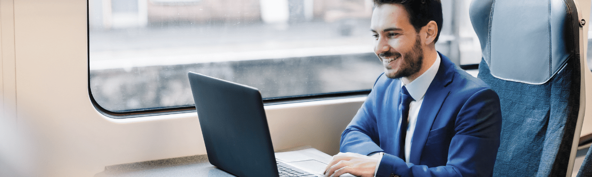 man sit in the train with a laptop