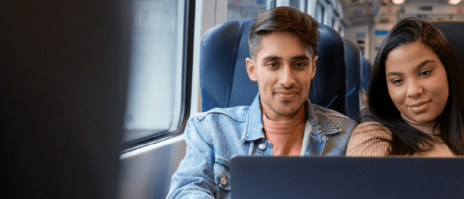 2 people watch a movie on the train