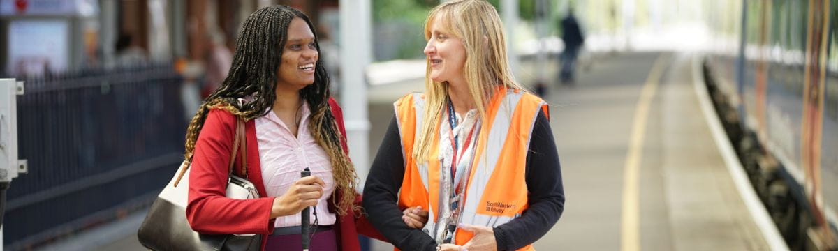 A customer and SWR team member at one of South Western Railway stations being assisted