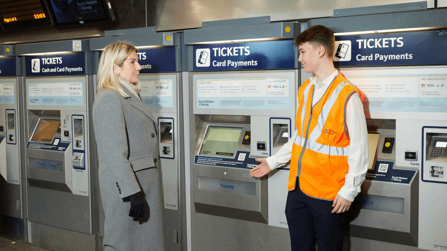 two people in front of a TVM machine