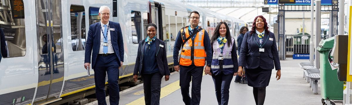 A group of South Western Railway employees by a train at London Waterloo railway station
