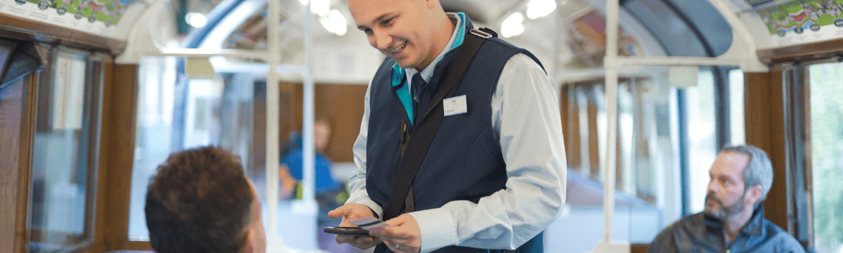 Guard on board the train checks a customer's ticket