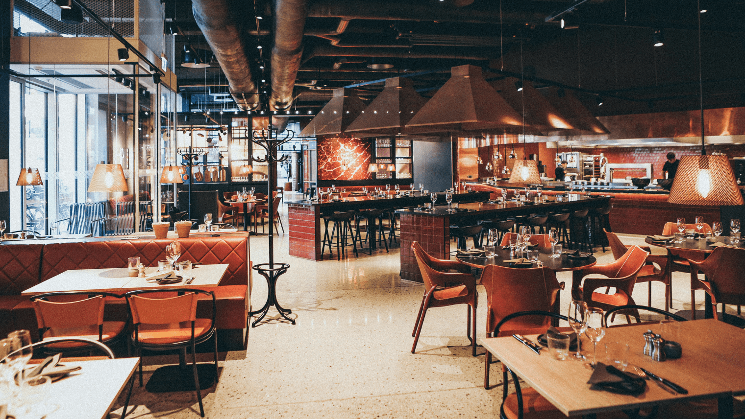 A restaurant with cutlery and glass on the tables