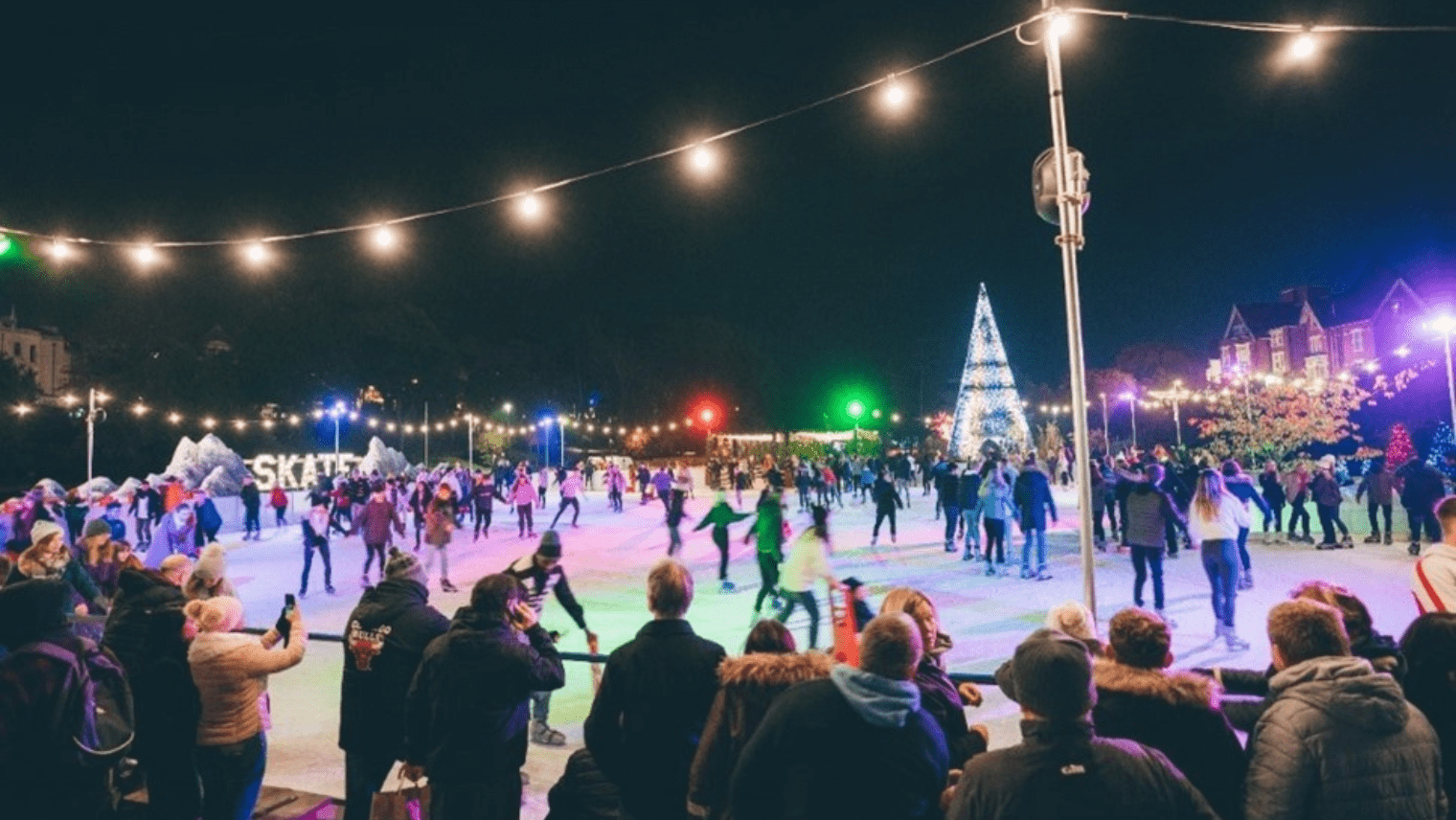 A group of people skating on an ice rink