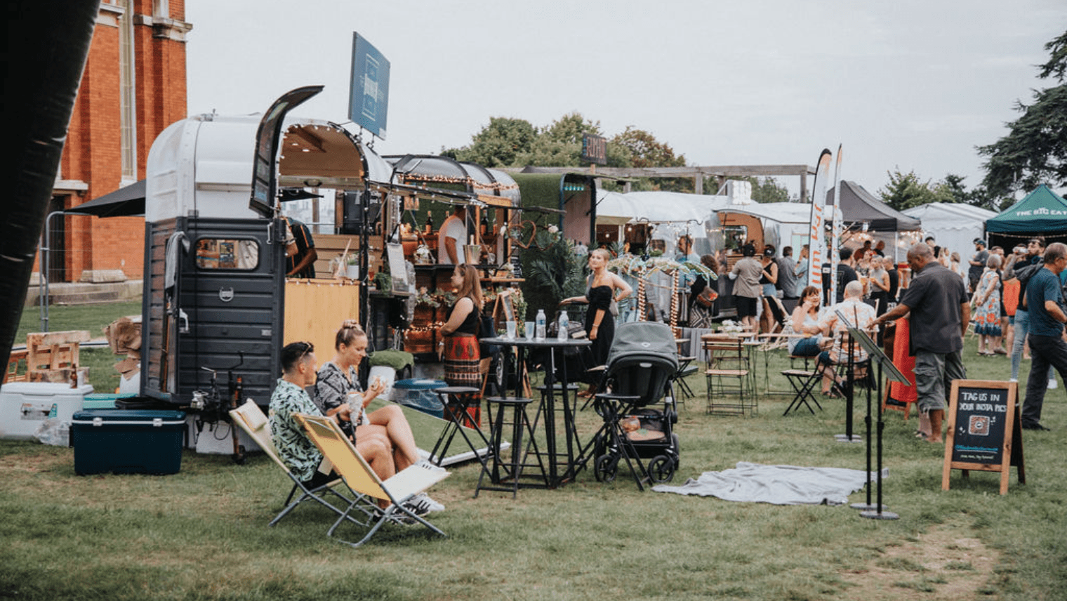 food trucks in a park, with people around