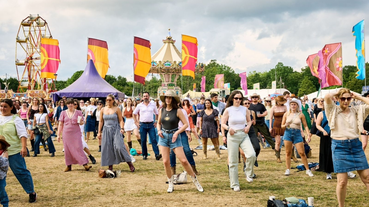  People dancing in an open field at a festival