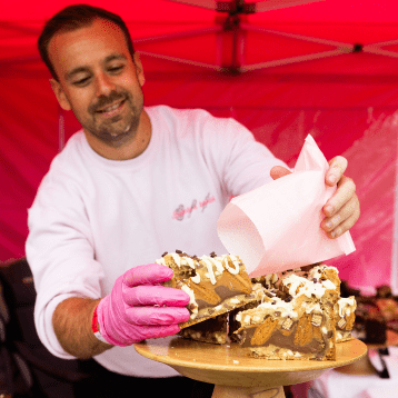  a man plating a cake up on a cake stand 