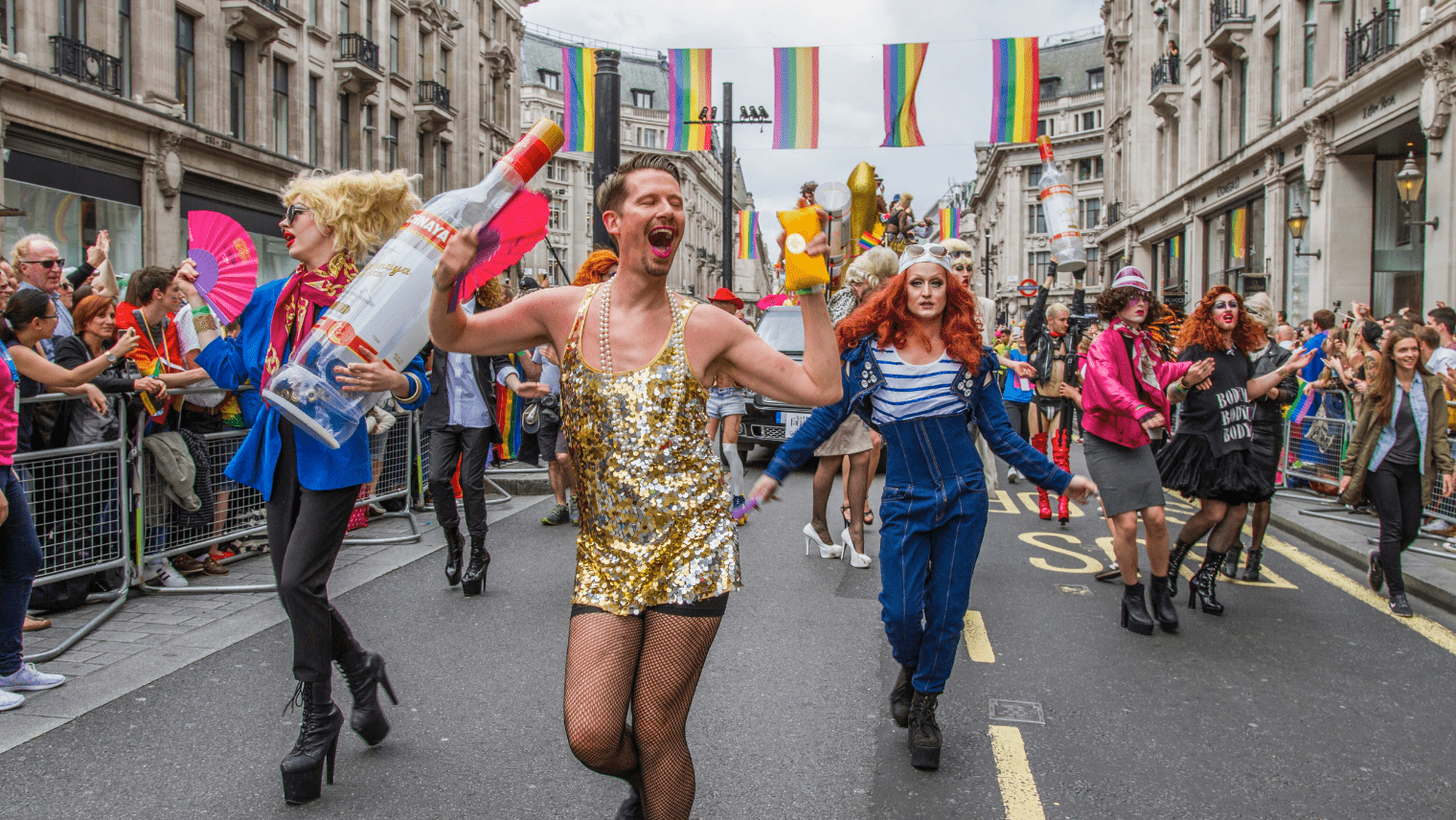 Image of a large crowd at a Pride event marching the streets in colourful clothing