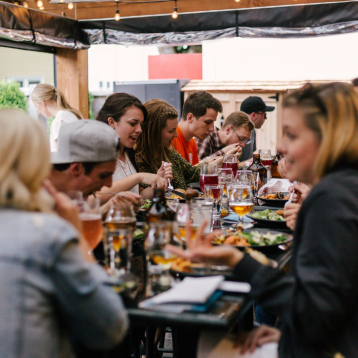 Image of a group of people sat around the table at a restaurant