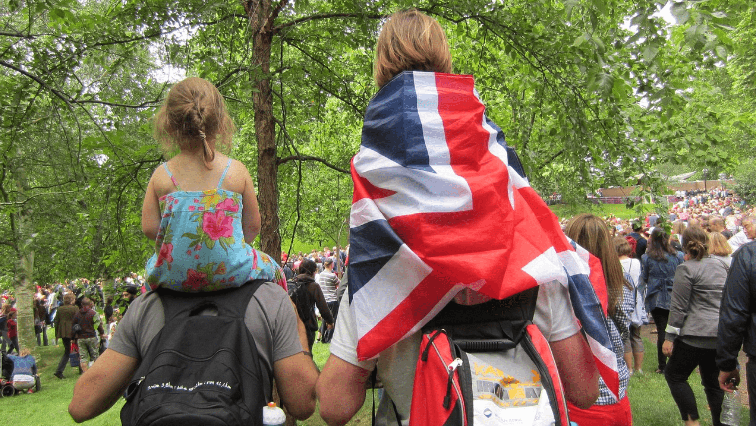 2 men with their children on their shoulders walking through Hyde Park