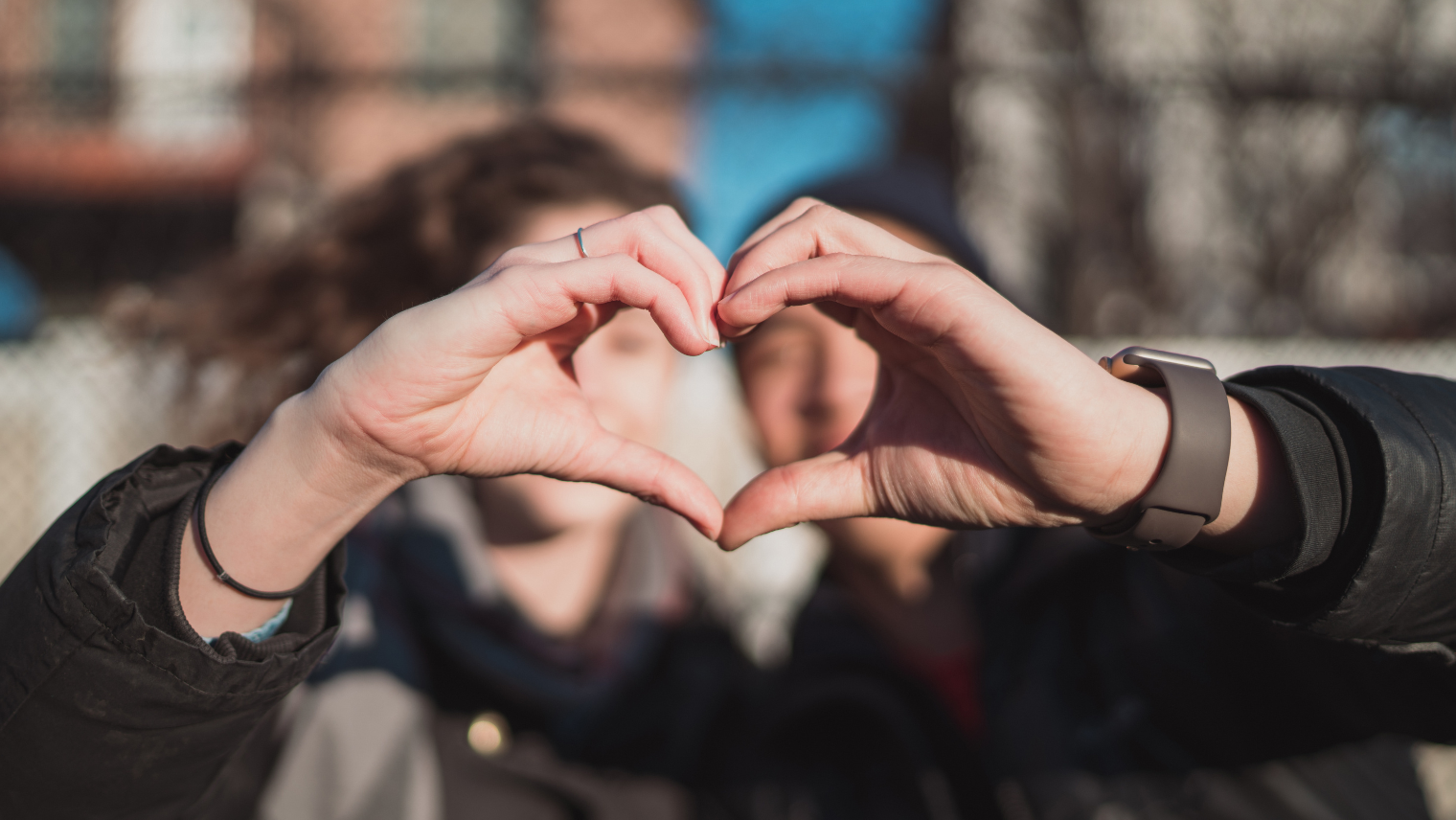 A couple making a love heart shape with their hands