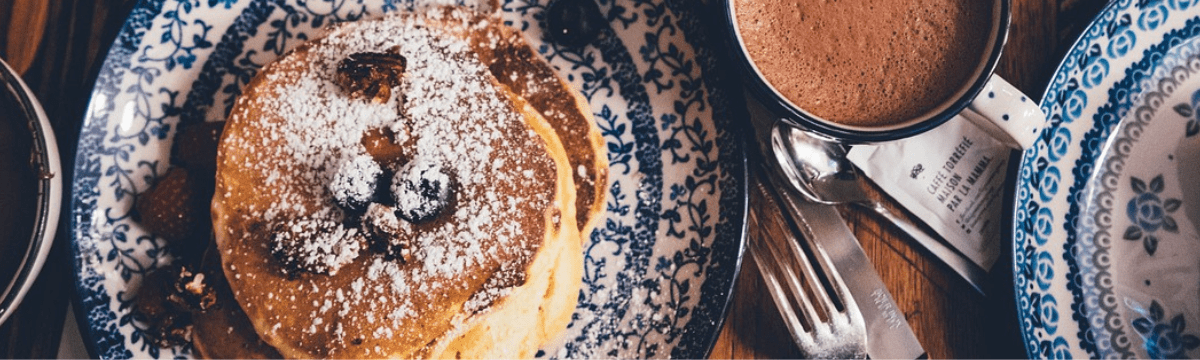 Pancakes on a table with hot drinks