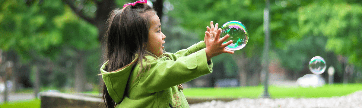 girl play with soap ball in the park