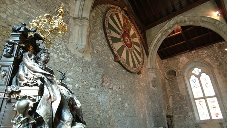 Body Image - a statue of Queen Victoria at the Great Hall, Winchester. The 'round table' from King Arthur's mythology hangs on the wall in the background.